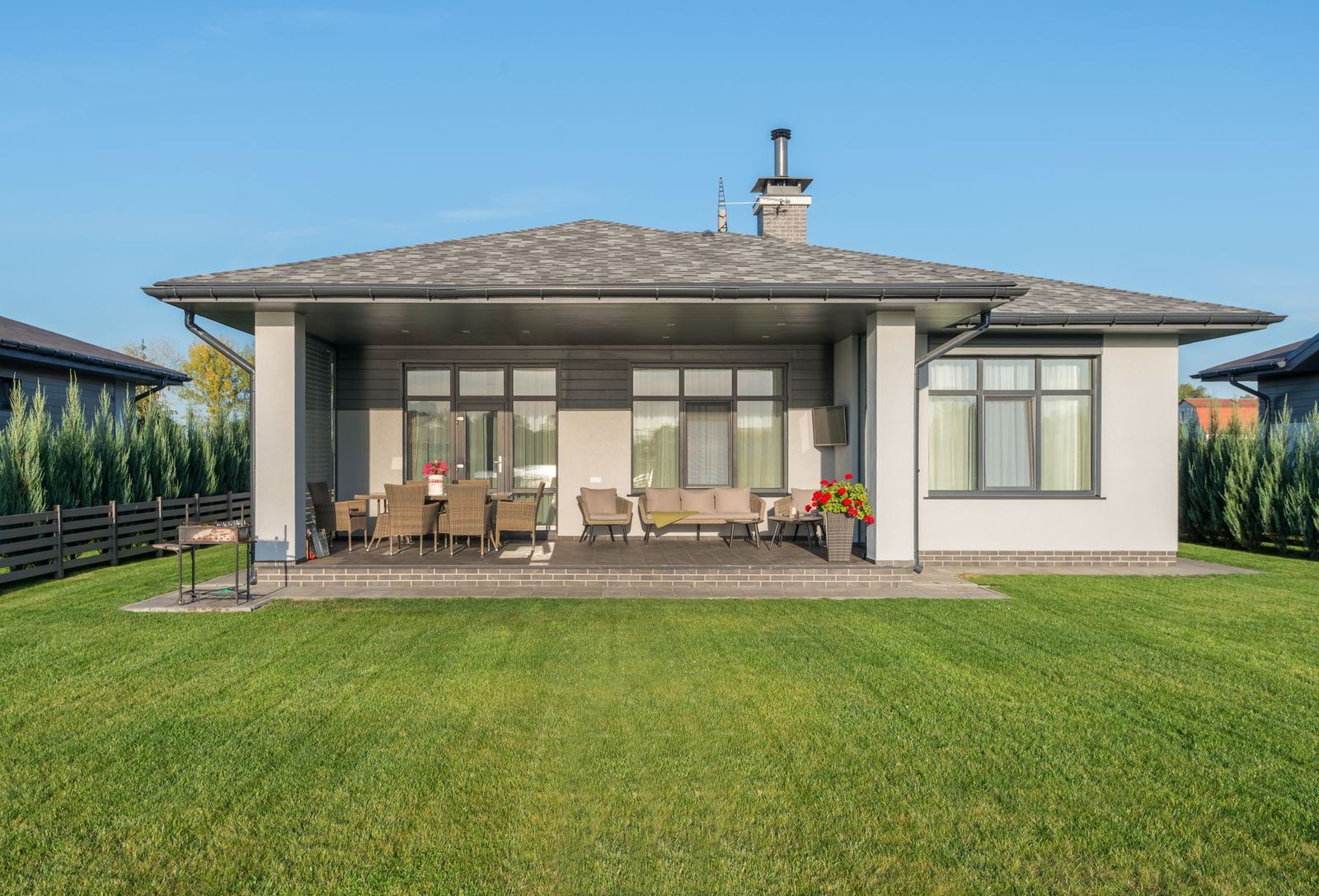 Modernes Haus mit großer Terrasse und gepflegtem Rasen